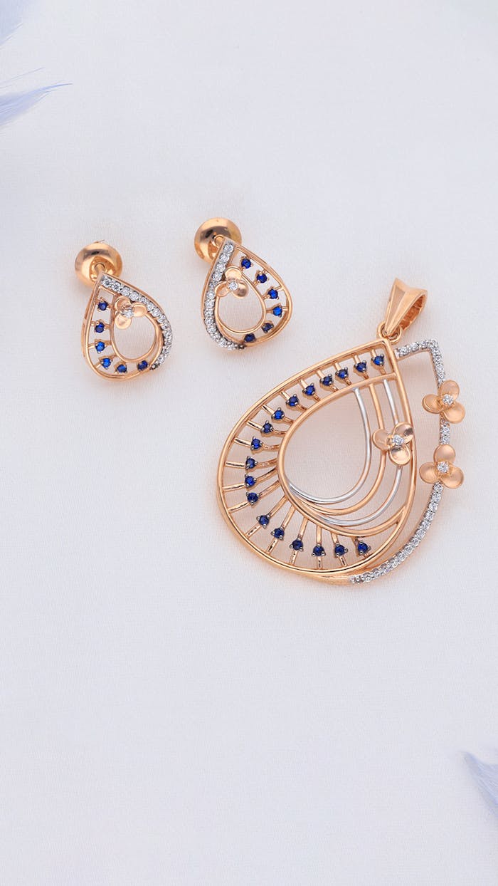 Stunning close-up of a gold pendant and earrings with blue gemstones.